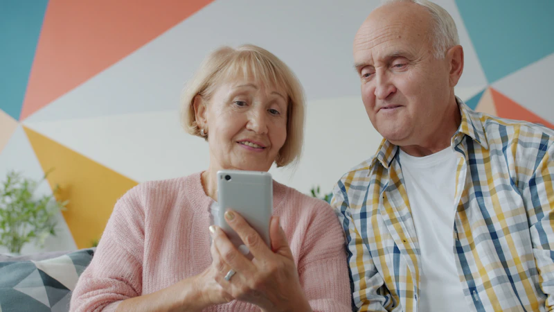 Senior couple looking at a smartphone together, representing connection and support