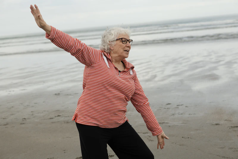 Senior performing slow, flowing tai chi movements outdoors to improve balance and reduce pain