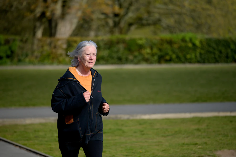 Senior woman walking briskly in a park, demonstrating gentle low-impact exercise for sore knees