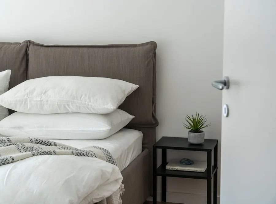 Cosy bedroom with warm golden light and inviting linen, representing the ideal sleep environment