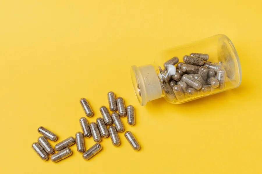 Natural health supplement capsules and pills arranged on a wooden surface