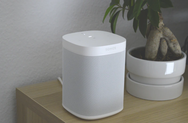 Senior speaking to a smart speaker voice assistant in their home for hands-free convenience