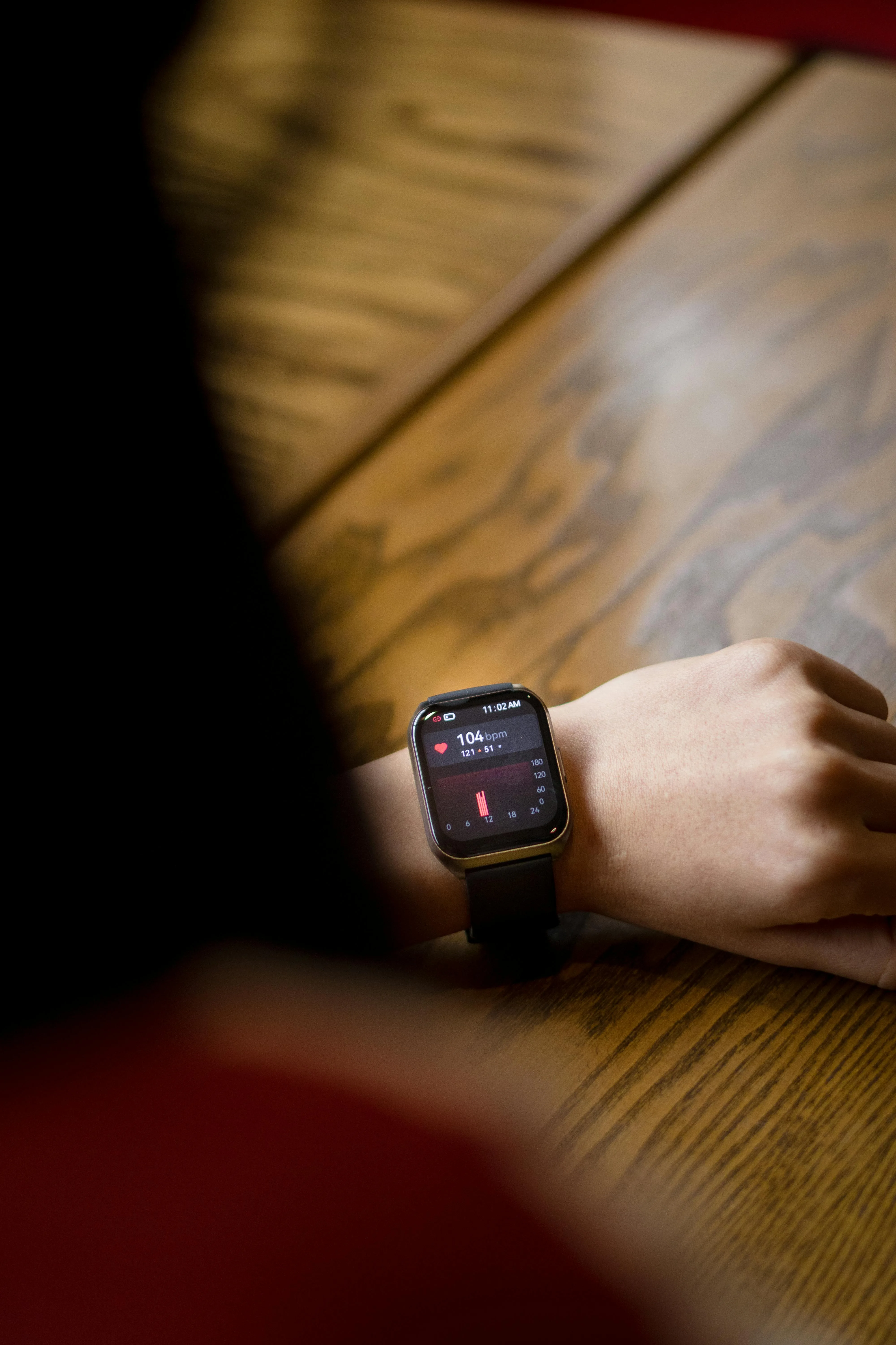 Smartwatch on a wrist showing a heart rate reading of 104 bpm