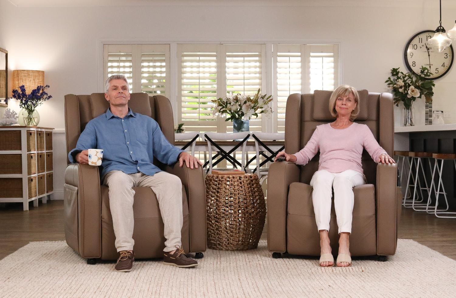 A couple relaxing in two Niagara recliner chairs in a bright lounge room